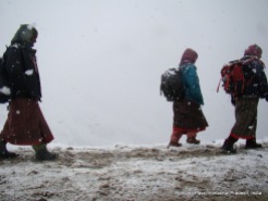 women walking under snow at rohtang pass, india